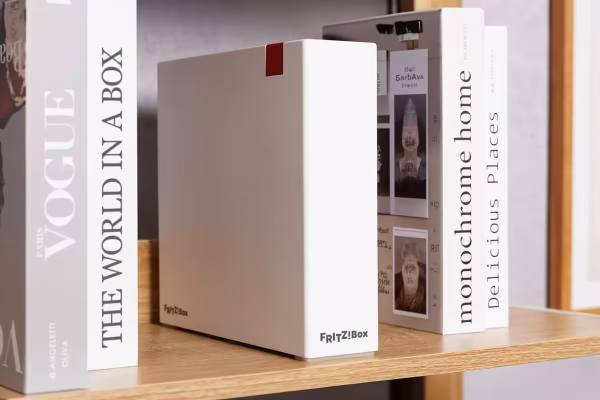 Boîte FRITZ!Box AVM posée sur une étagère avec livres Vogue et monochrome home