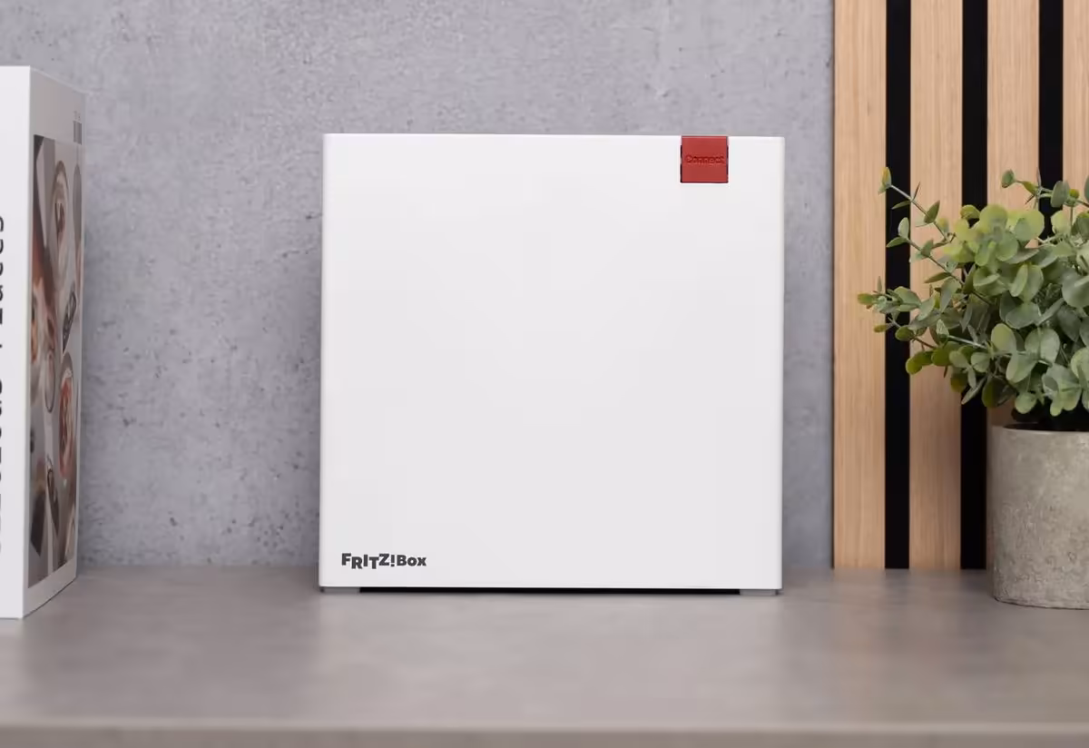 Boîte FRITZ!Box AVM blanche avec logo rouge, posée sur une table près d’une plante