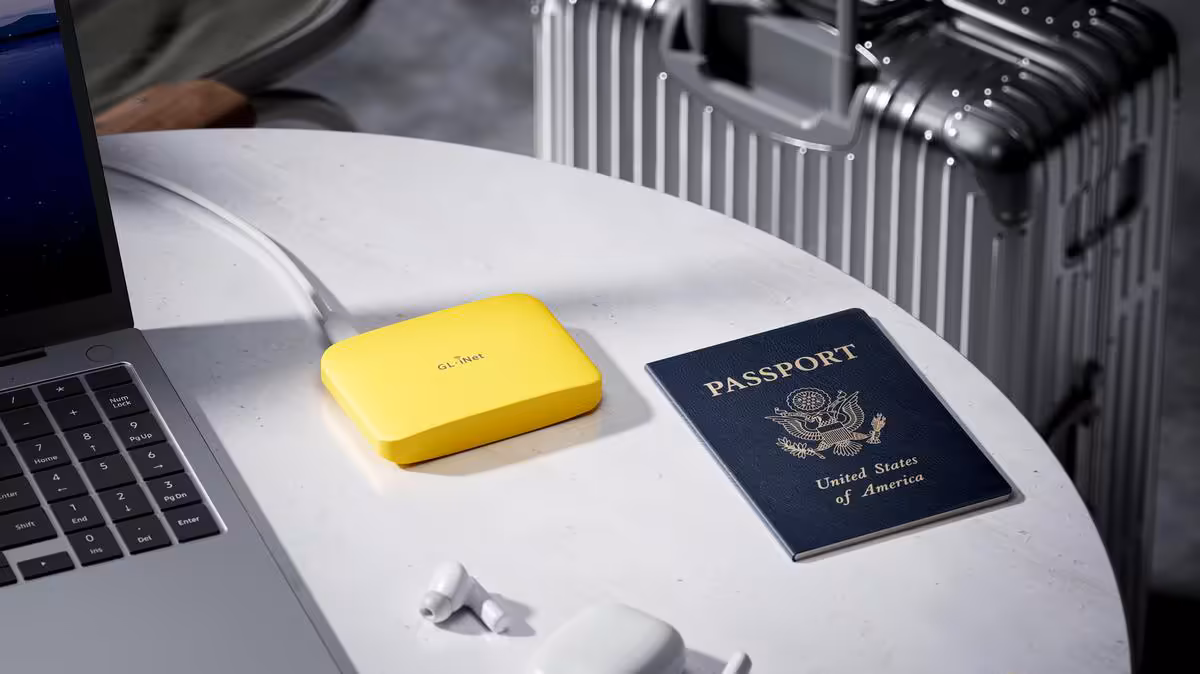 Routeur GL.iNet Mango 2 sur table de voyage avec ordinateur portable, passeport et valise