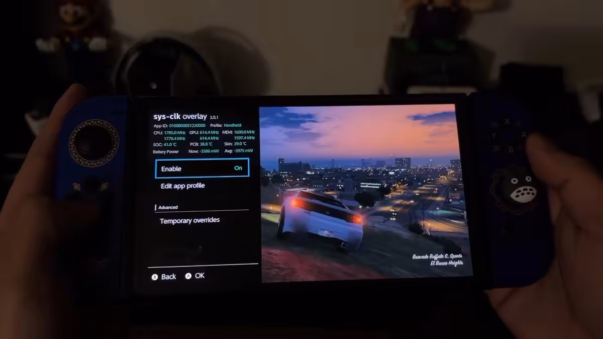 GTA 5 sur Nintendo Switch : un port natif amateur tourne sur la console d'origine 2 Nintendo Switch OLED bleue affichant l’overlay sys-clk avec GTA 5 au coucher du soleil