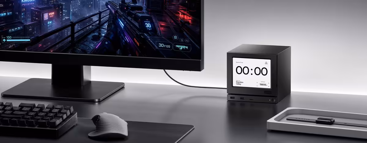 JSAUX Steam Machine : deux façades E-Ink et Pixel Matrix désormais disponibles 5 Mini PC JSAUX Gaming E-Ink affichant l’heure sur un bureau avec écran et périphériques