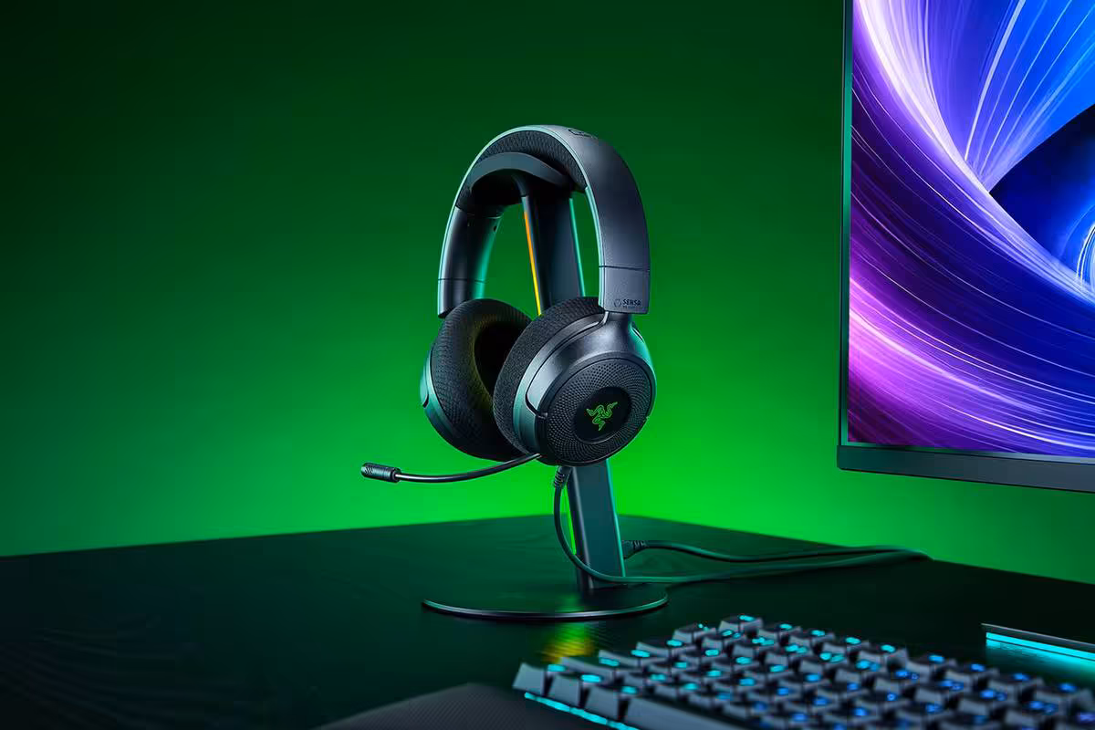 Casque gaming Razer noir sur support, micro visible, devant écran et clavier RGB
