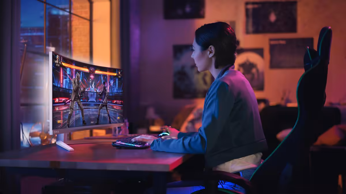 Philips Evnia 34M2C8600P : un QD-OLED 34 pouces 280 Hz taillé pour jouer et travailler 2 Joueur sur PC devant un écran gaming lumineux, ambiance néon violette et bleue, setup bureau