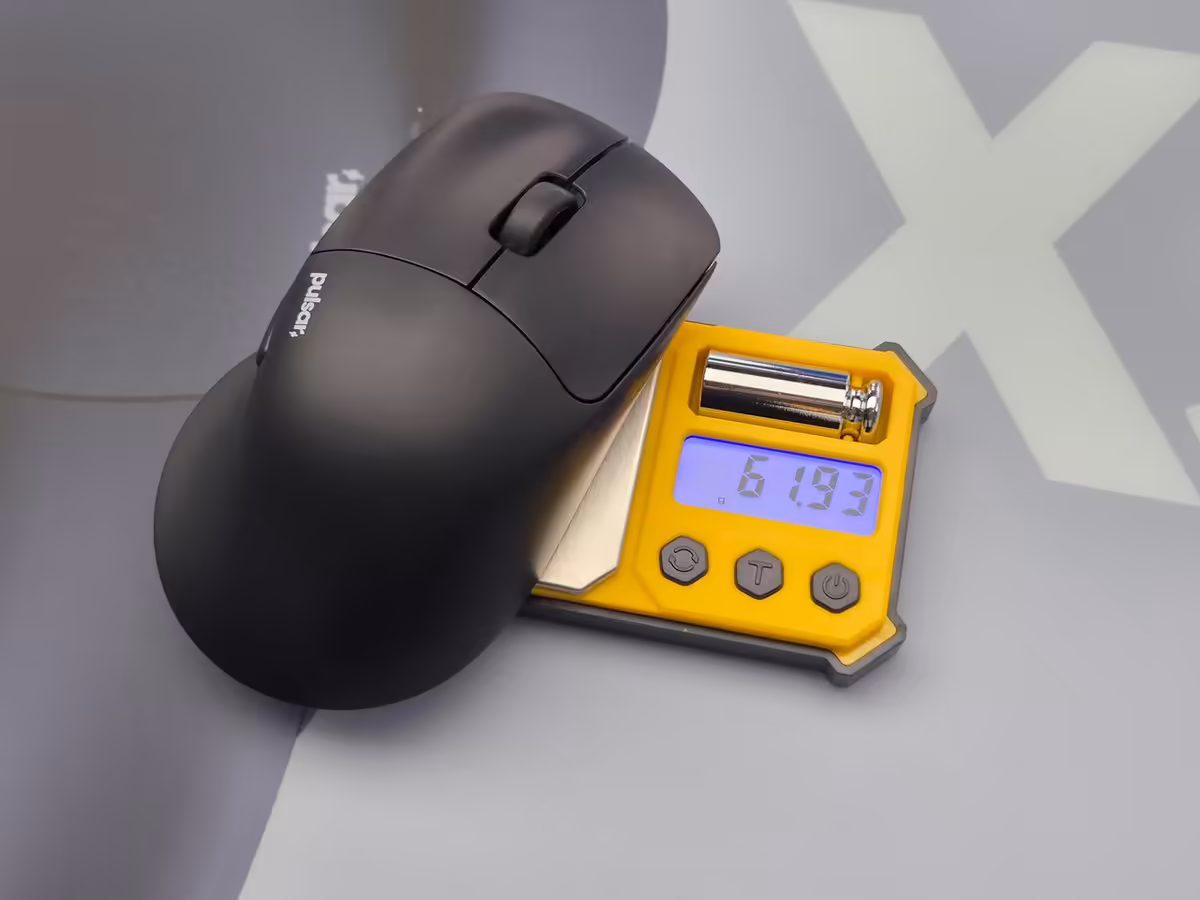 Pulsar X5 : une souris gaming ergonomique de 62 g pensée pour les grandes mains 2 Souris Pulsar X5 noire posée sur balance numérique affichant 61,93 g