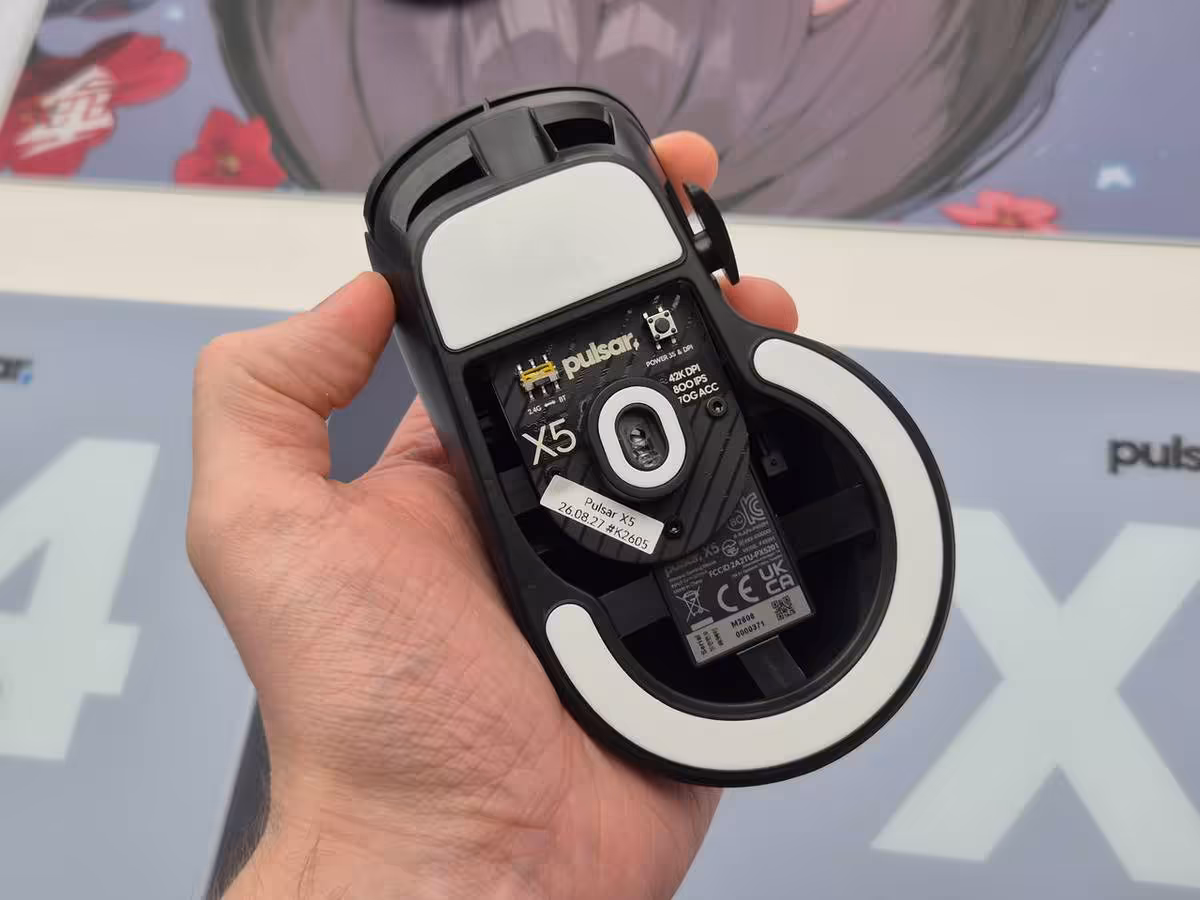 Pulsar X5 : une souris gaming ergonomique de 62 g pensée pour les grandes mains 4 Pulsar X5 ouverte dessous, avec patins blancs, capteur central et marquage du modèle X5