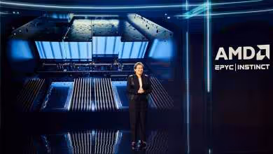 Lisa Su devant une puce géante lors d’une présentation AMD EPYC Instinct