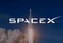 Fusée SpaceX en décollage nocturne, logo SpaceX visible devant un panache de fumée