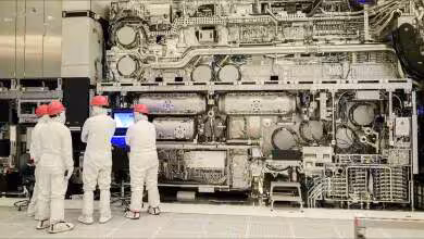 Machine de lithographie High-NA EUV Intel en salle blanche, techniciens inspectant un immense équipement industriel complexe
