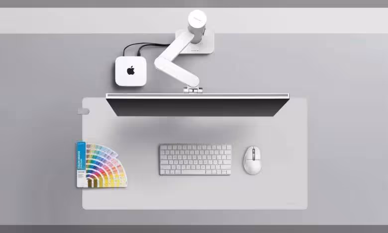 INFTYLAB lance des accessoires Mac signés BenQ avec bras écran, souris et desk mat 1 Poste de travail Apple minimaliste avec moniteur, clavier, souris et nuancier de couleurs BenQ sur tapis gris.