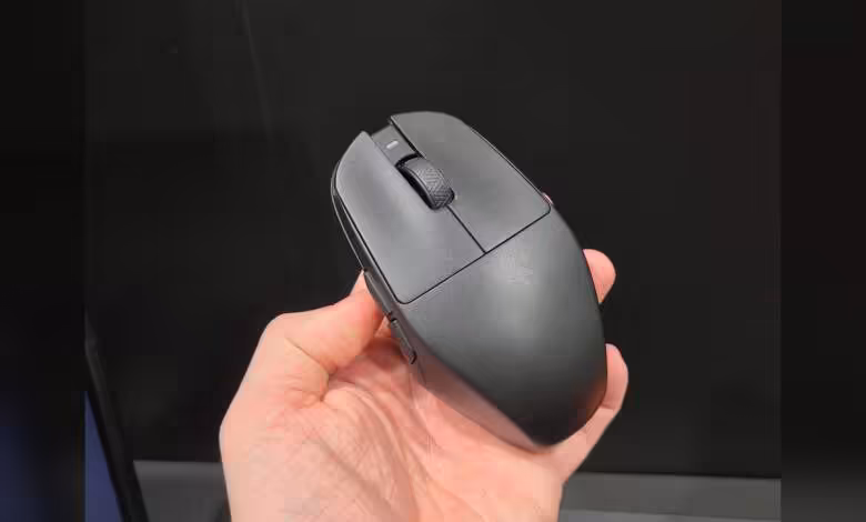 Teevolution Kira : une souris sans fil qui ressuscite clairement l’esprit de la Logitech G303 1 Souris sans fil noire vue de dessus, tenue en main, avec molette centrale et boutons principaux visibles