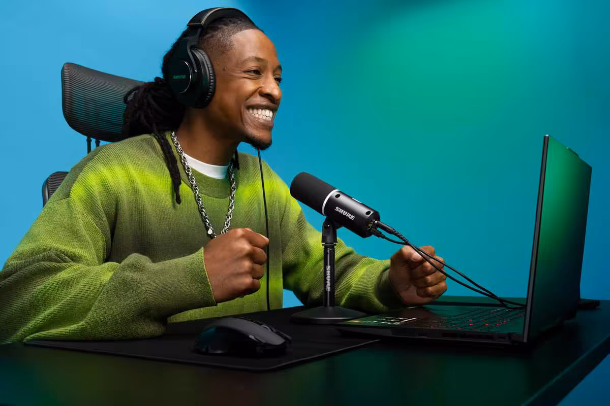 Shure MV6 Gen 2 : le microphone USB affine automatiquement voix et bruits parasites 5 Créateur portant un casque utilise le microphone USB Shure MV6 Gen 2 noir devant un ordinateur portable