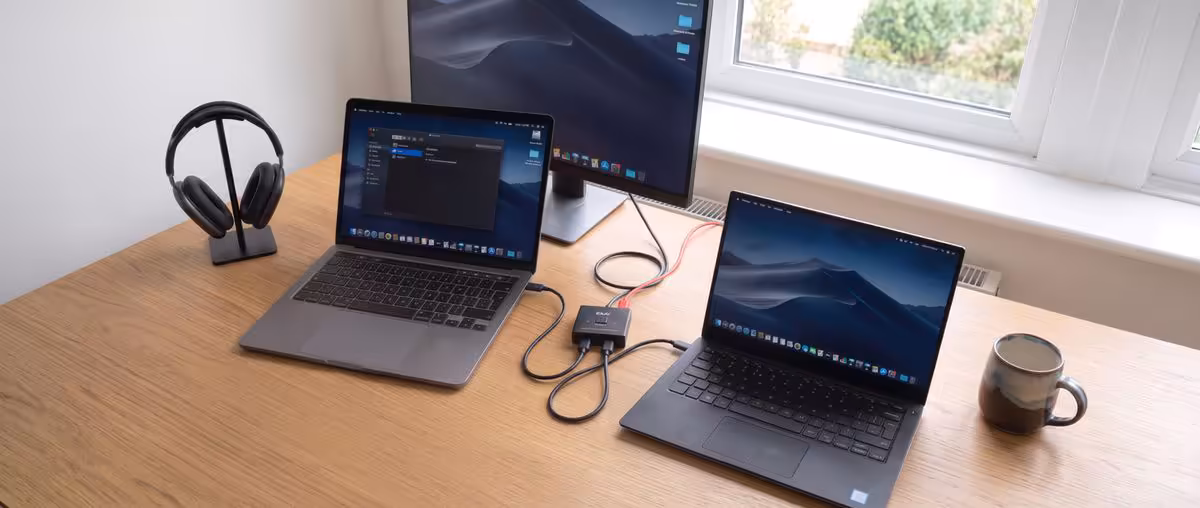 Bureau avec deux MacBook, dock USB-C compact, casque et moniteur externe, configuration de travail connectée