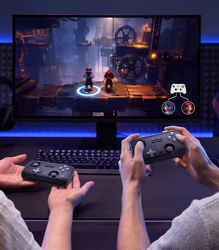 Deux joueurs utilisent des manettes Voidjoy sur PC, avec écran de jeu et ambiance gaming