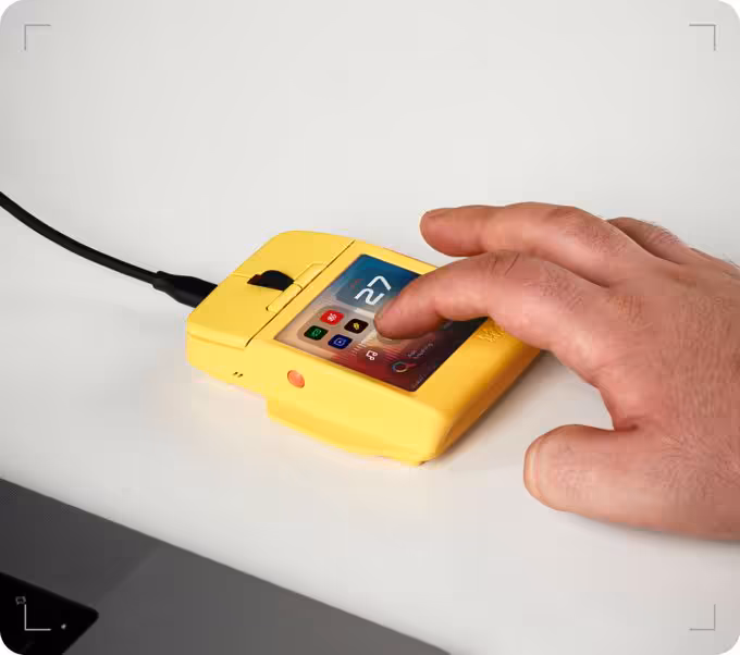 Arctic Fox Super Mouse : un écran tactile 720p de 3,1 pouces sous les doigts 2 Main utilisant la souris tactile jaune Arctic Fox Super Mouse sur un bureau, reliée par câble USB