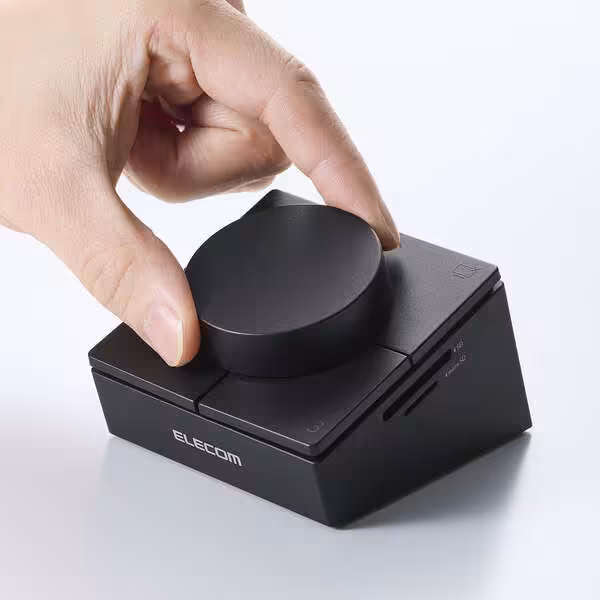 Dock USB-C Elecom : une molette programmable et quatre touches dans un hub 8-en-1 3 Main manipulant la molette rotative du contrôleur programmable Elecom noir