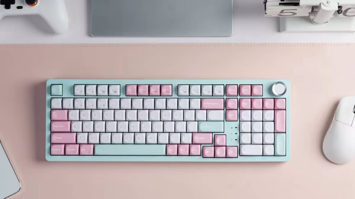 Clavier sans fil Keychron J3 SE pastel vert menthe et rose, photographié sur un bureau rose