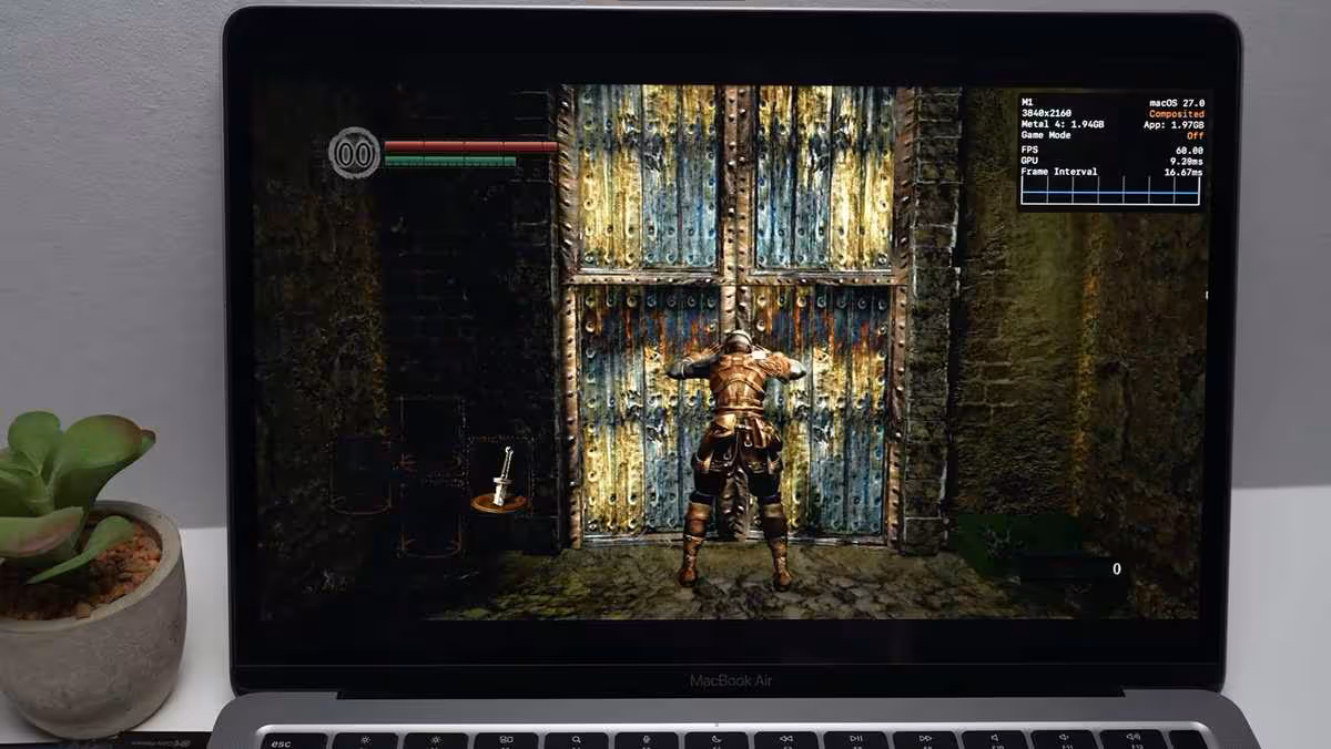 nxnative fait tourner les jeux Nintendo Switch nativement sur les puces Apple 2 MacBook Air affichant Dark Souls Remastered en jeu, posé sur un bureau à côté d’une plante