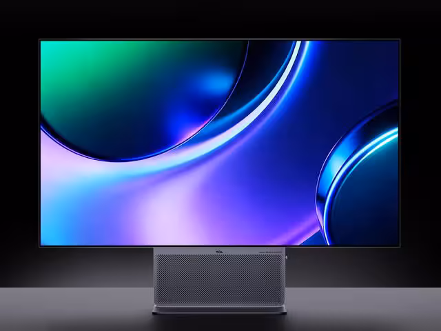 OLED 700 Hz : TCL prépare des dalles grand format imprimées pour 2028 3 Moniteur OLED TCL grand format affichant un fond abstrait bleu, vert et violet sur son pied métallique