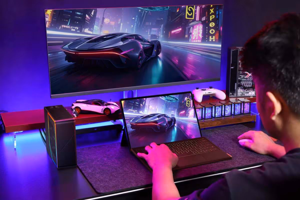 OneXPlayer Super X Pro : Ryzen AI MAX+ 495, 192 Go et refroidissement liquide 2 OneXPlayer Super X Pro utilisé sur un bureau gaming avec écran externe et éclairage violet