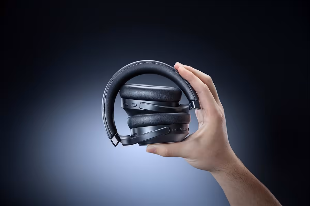 Razer Barracuda V2 Pro : ANC hybride, double connexion et 70 heures d’autonomie 3 Casque sans fil Razer Barracuda V2 Pro plié, tenu à la main sur fond sombre