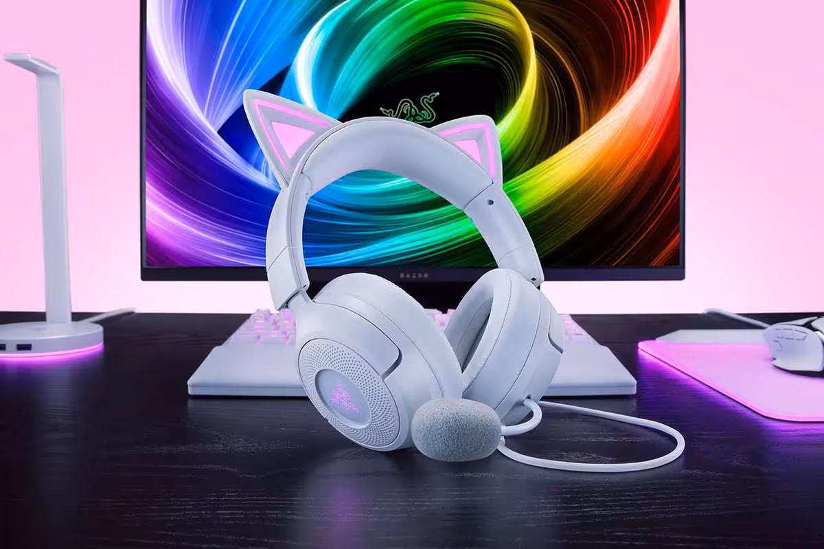 Casque Razer Kraken Kitty V3 blanc posé devant écran, clavier et accessoires RGB