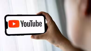 Smartphone tenu horizontalement affichant le logo YouTube rouge et noir sur écran blanc