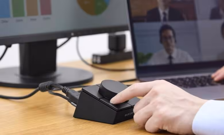 Dock USB-C Elecom : une molette programmable et quatre touches dans un hub 8-en-1 1 Molette programmable Elecom utilisée sur un bureau, reliée à un ordinateur portable et un écran externe