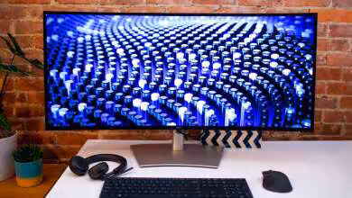 Écran Dell incurvé ultralarge sur bureau, affichant motifs bleus, avec clavier, souris et casque noir
