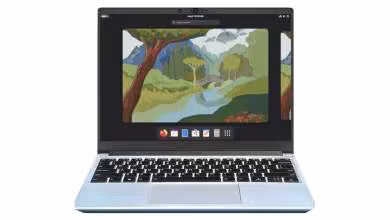 Ordinateur portable affichant le bureau Fedora Linux avec fond d’écran paysage et dock d’applications