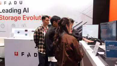 Stand FADU présentant ses solutions de stockage IA, avec écrans de démonstration et visiteurs au salon ტექნologique