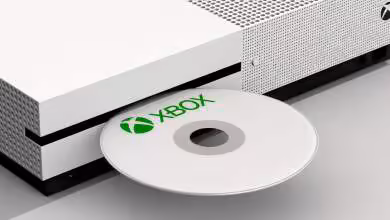 Console Xbox One S blanche avec disque physique Xbox posé devant le lecteur