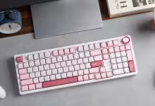 Clavier sans fil Keychron J3 SE rose et blanc sur bureau, avec ordinateur portable, souris et manette