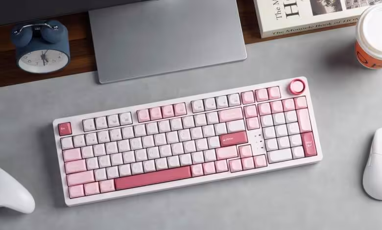 Clavier sans fil Keychron J3 SE rose et blanc sur bureau, avec ordinateur portable, souris et manette