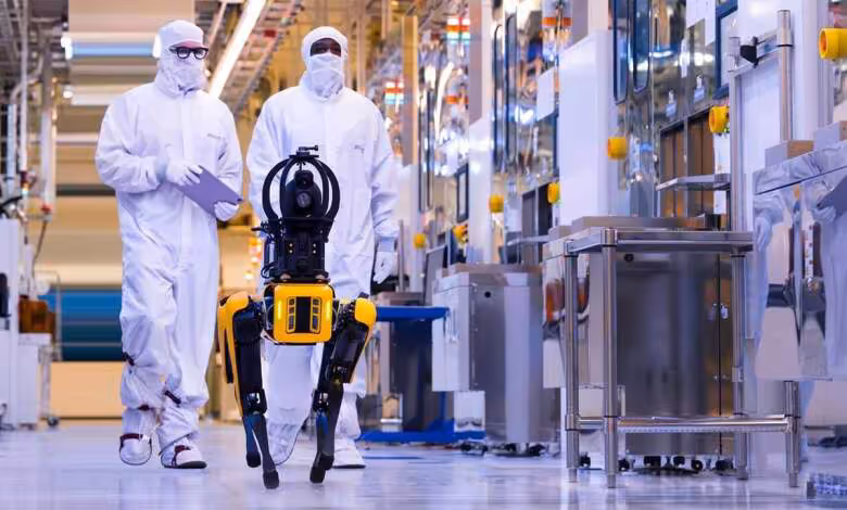 Techniciens Micron en salle blanche testant un robot industriel dans une usine de fabrication de mémoire