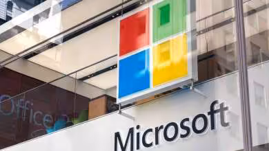 Façade vitrée d’un bâtiment Microsoft avec logo quatre carrés colorés et enseigne Microsoft blanche