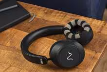 Casque EEG Neurable One noir posé sur un bureau en bois près d’un ordinateur portable