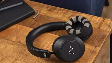Casque EEG Neurable One noir posé sur un bureau en bois près d’un ordinateur portable