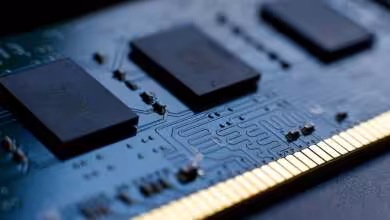 Gros plan d’une barrette de mémoire RAM avec puces noires et connecteurs dorés