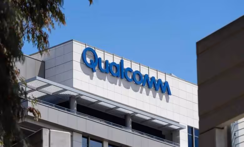 Qualcomm contre Arm : une victoire à 2 dollars qui pourrait coûter des milliards 1 Logo Qualcomm bleu sur la façade vitrée du siège de l’entreprise sous un ciel dégagé