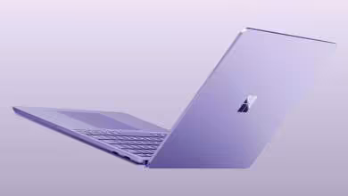 Ordinateur portable Microsoft Surface violet ouvert, vu de profil sur fond lavande