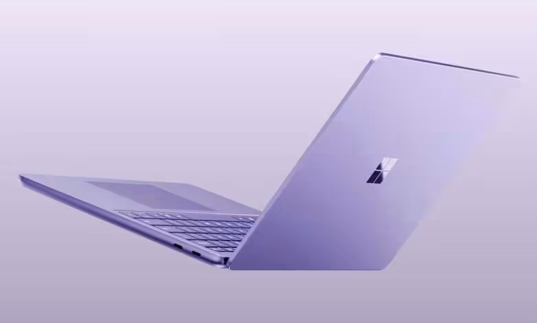 Ordinateur portable Microsoft Surface violet ouvert, vu de profil sur fond lavande