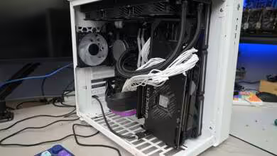 Carte graphique NVIDIA GeForce RTX en montage vertical dans un boîtier blanc sur bureau