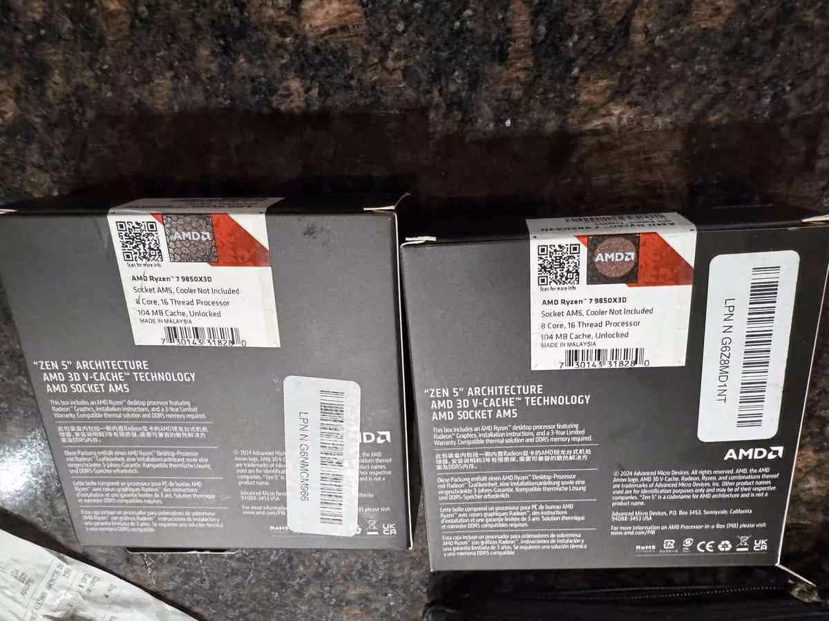 Deux boîtes AMD Ryzen 7 9850X3D vues de dos sur un plan de travail