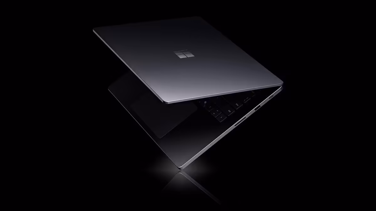 Deux ordinateurs portables Microsoft Surface Laptop Ultra noirs, l’un fermé et l’autre partiellement ouvert